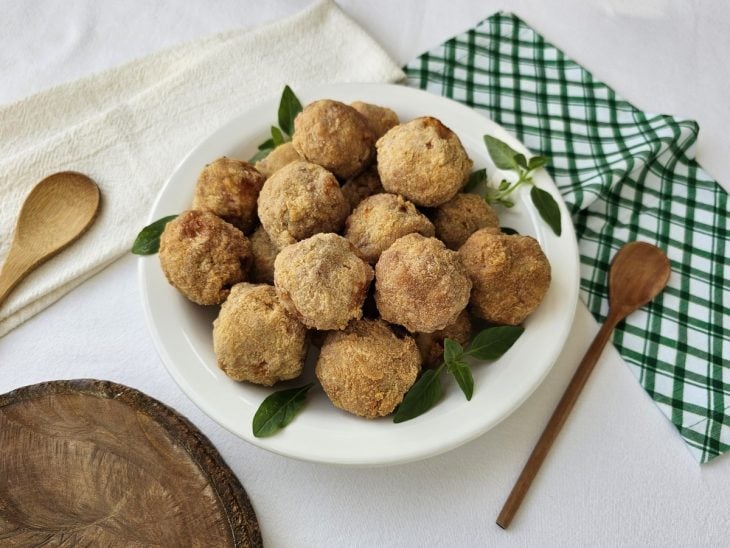 Um prato contendo bolinho de linguiça com queijo.