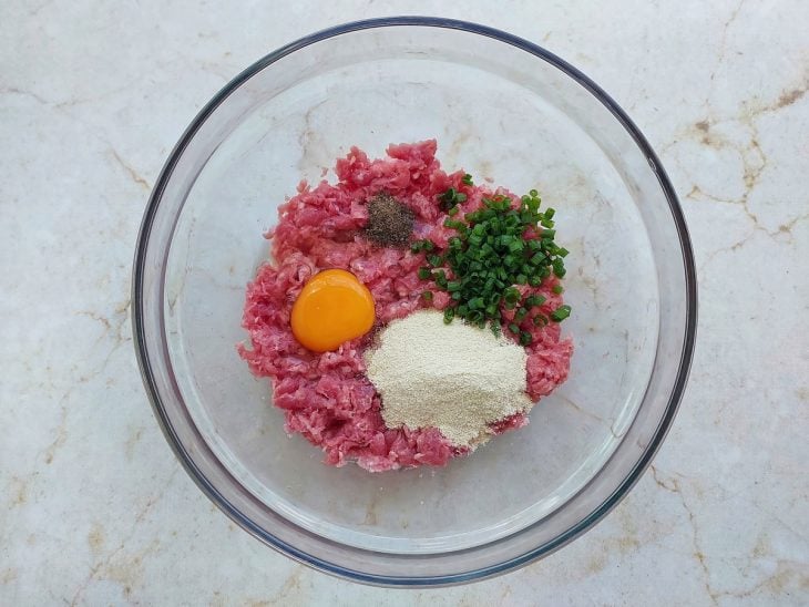 Numa tigela, ingredientes adicionados a carne.