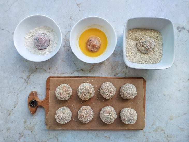 Bolinhos sendo empanados na farinha de trigo, ovos e panko.