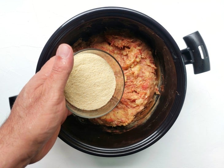 Farinha de rosca sendo adicionada na panela com os outros ingredientes.