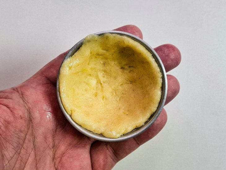 Forminha de empada untada com óleo e forrada com uma porção da massa de mandioca.