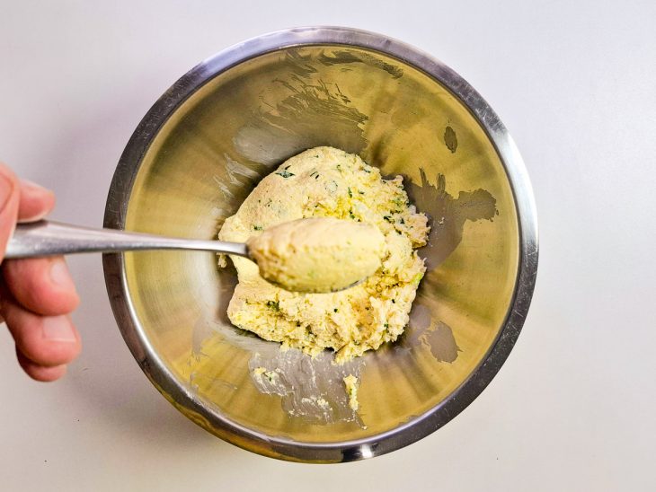 bolinho de milho boleado em colher de chá para fritar.