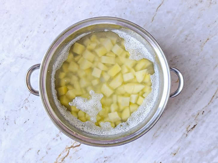 Batatas em cubos numa panela com água.