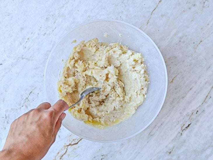 Batata amassada e frango desfiado incorporados numa tigela.