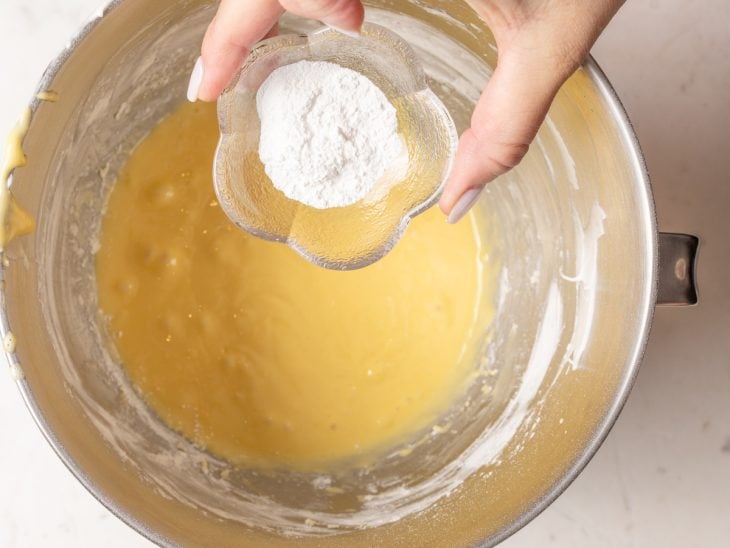 Uma tigela com gemas, açúcar, óleo, leite, baunilha, amido, farinha e fermento.