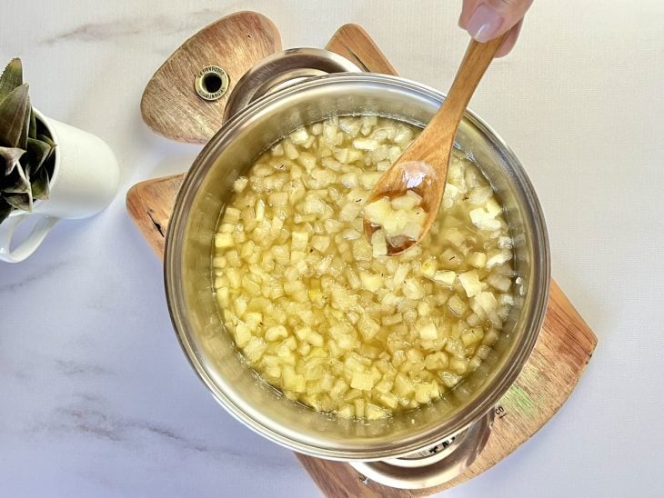 Uma panela cozinhando abacaxi com açúcar.