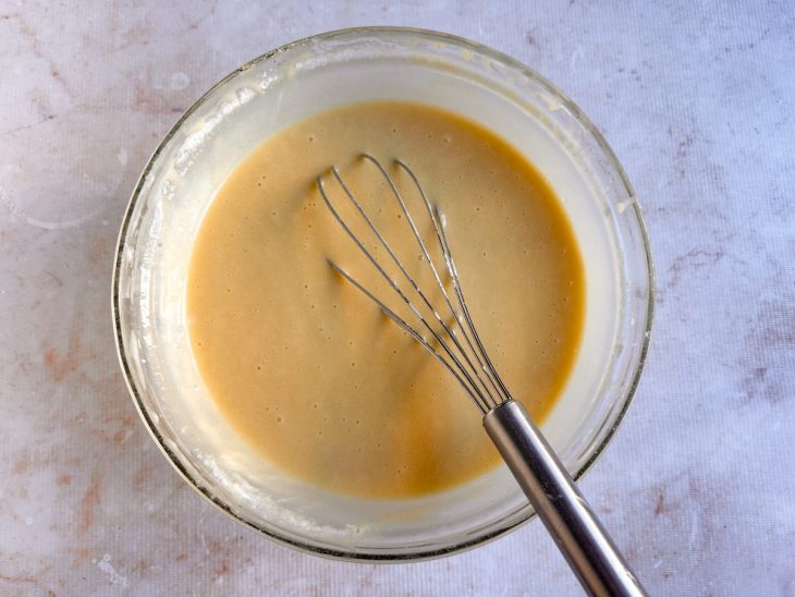 Farinha, leite, amido e fermento sendo misturados até formar uma massa lisa.