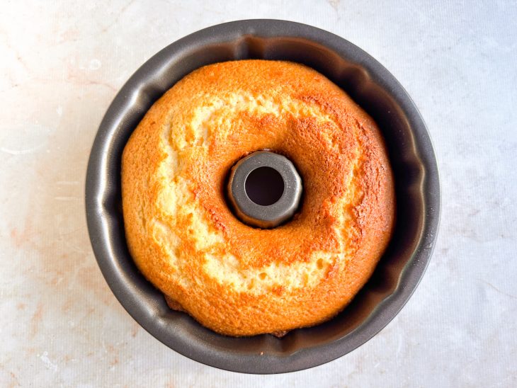 Bolo assado sendo retirado do forno para esfriar.