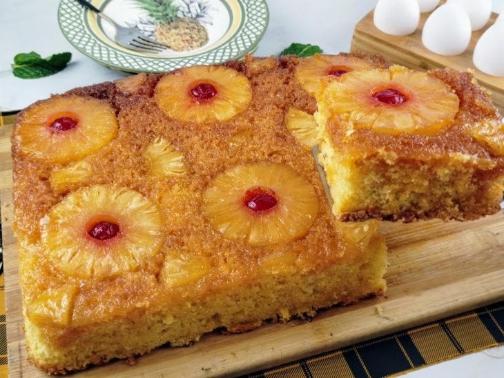 Fatia de bolo de abacaxi caramelizado sendo retirada.