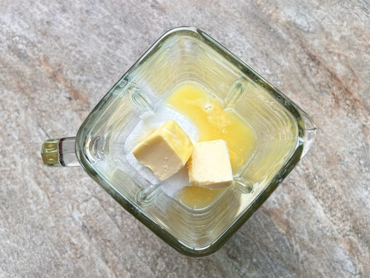 No liquidificador, os ovos, o açúcar, a manteiga, a farinha de trigo e o suco natural de abacaxi.
