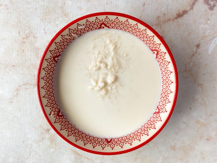 Arroz cru de molho no leite em uma tigela.