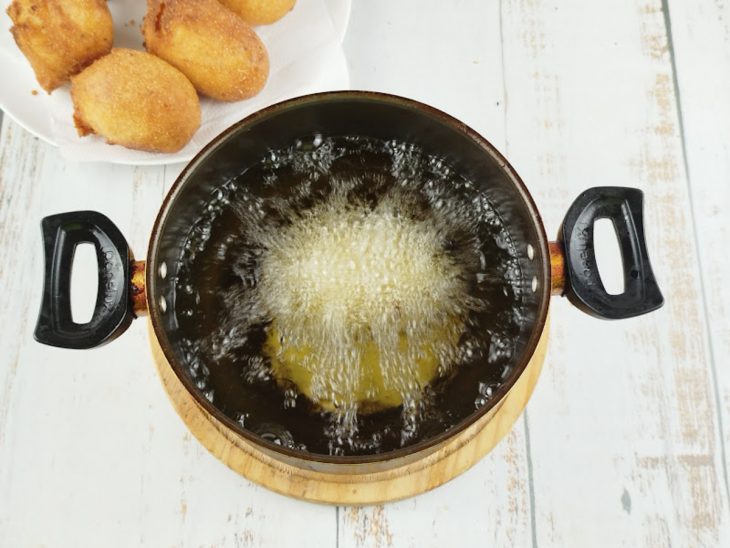 Bolinho fritando em óleo quente.
