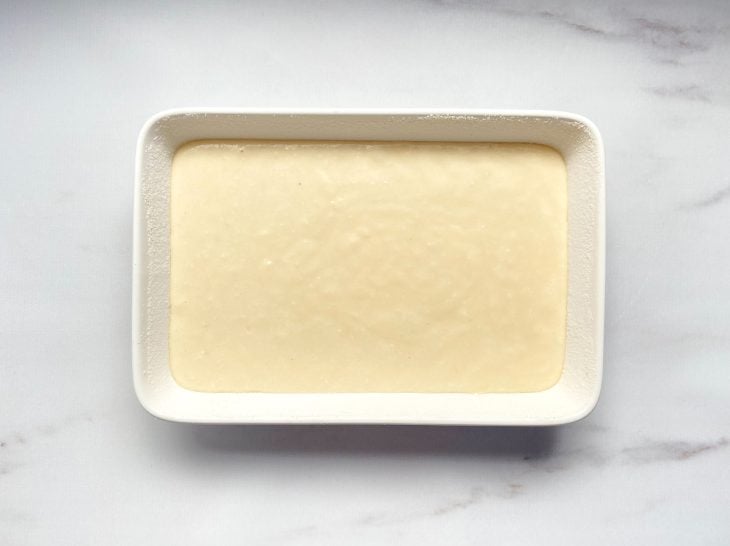 Uma forma com a massa crua do bolo de arroz.