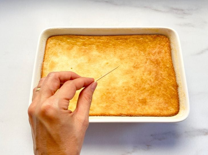 Uma forma contendo bolo de arroz sem leite e um palito.