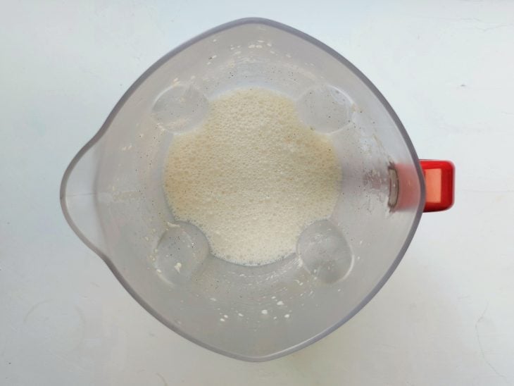 Um liquidificador contendo a mistura de ovos, leite, manteiga, o açúcar e canela.