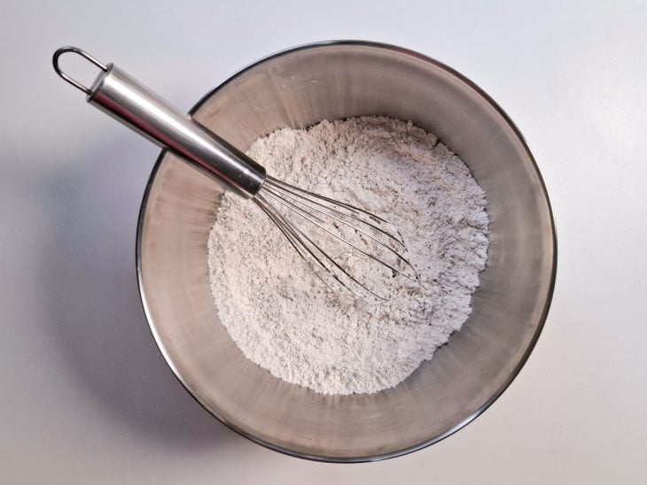 Farinha de aveia, polvilho doce e fermento em pó misturados em uma tigela.