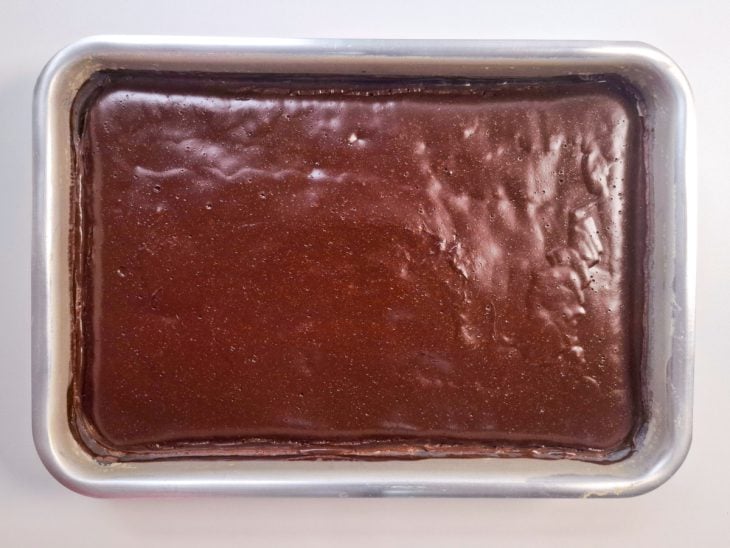Cobertura de chocolate adicionada sobre o bolo já assado.