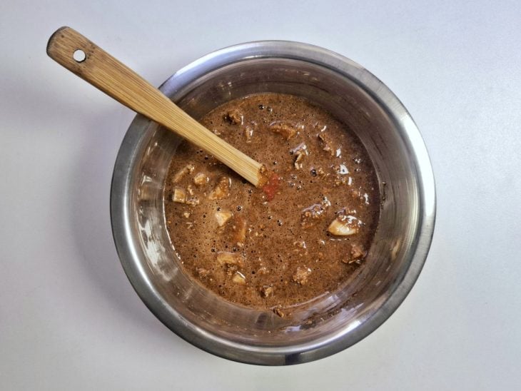 Cacau em pó, canela. farinha de linhaça e mel adicionados e incorporados na tigela redonda de inox.