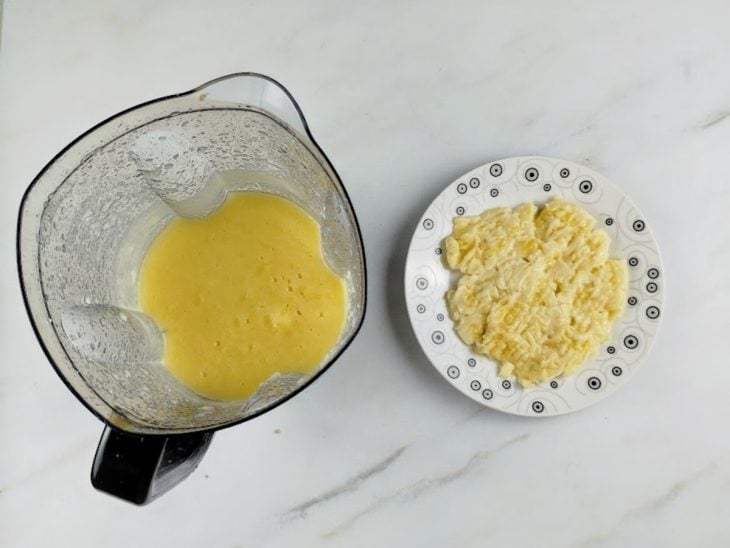 Maçãs batidas com água no liquidificador e bananas amassadas em um prato.
