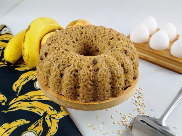 Bolo de aveia desenformado sobre uma boleira pronto para consumo.
