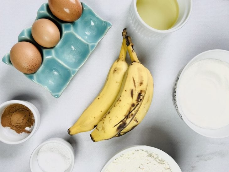 Ingredientes para a receita de bolo de banana com canela separados em uma bancada.