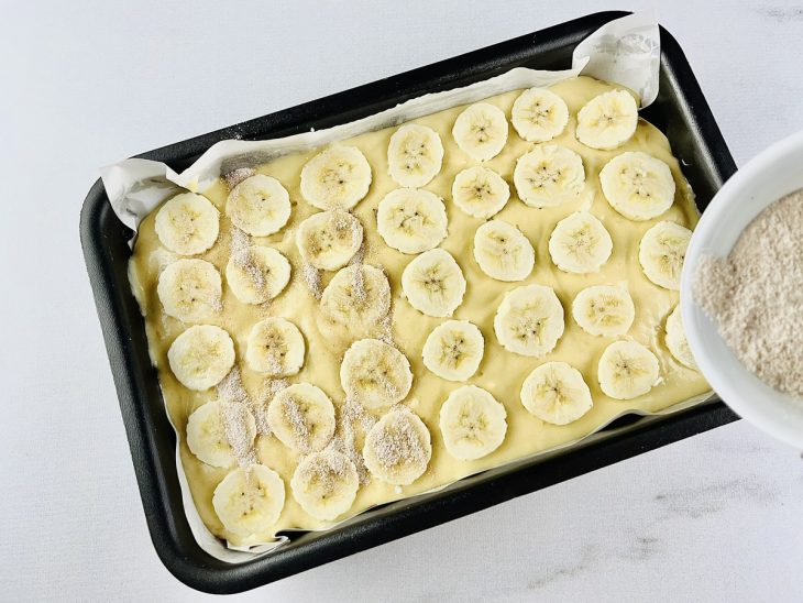 Rodelas de banana, açúcar e canela colocados na forma.