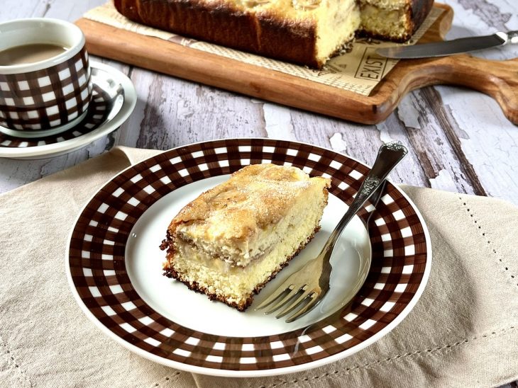 Fatia de bolo de banana com canela e açúcar servida num prato individual.