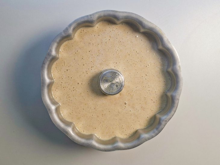 Farinha de rosca, canela e fermento sendo adicionados à massa.