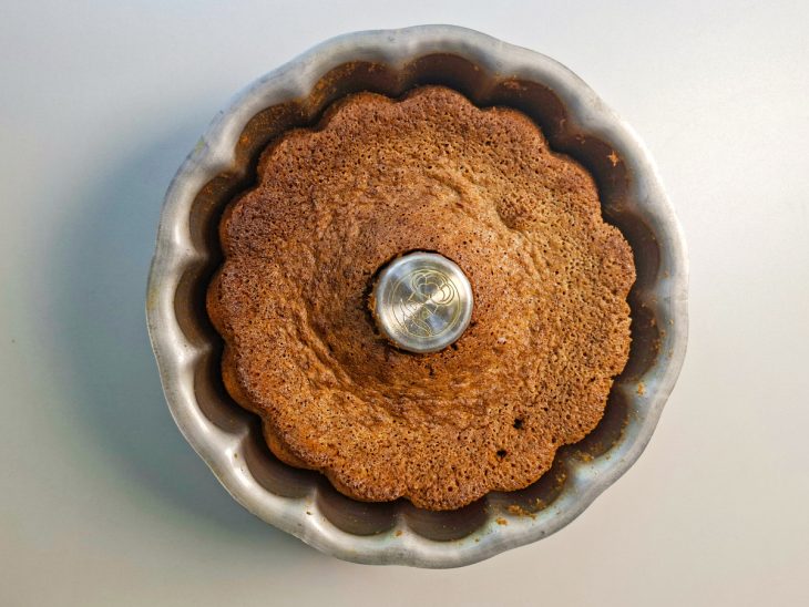 Bolo assado e dourado ainda dentro da forma.