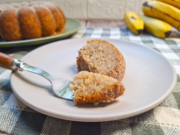 Bolo desenformado e finalizado com açúcar e canela por cima.