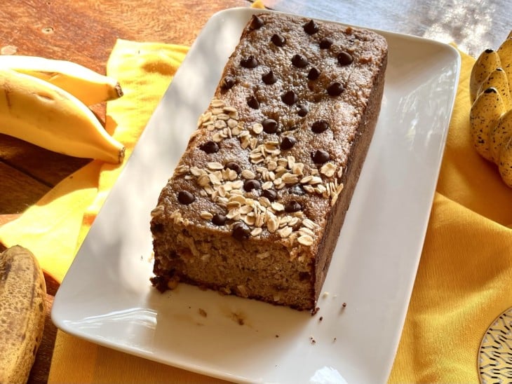 Uma bancada contendo um bolo de banana com uva-passa.