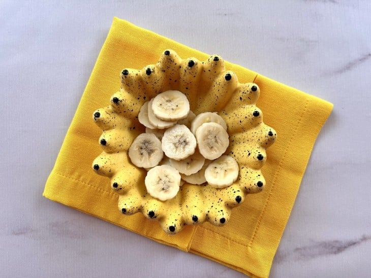 Recipiente com bananas cortadas em rodelas.