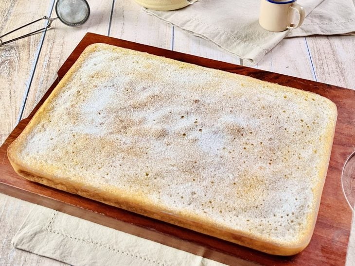 Bolo desenformado sobre uma tábua pronto para consumo.