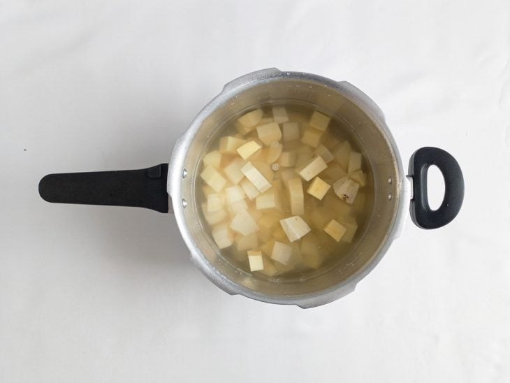Cubos de batata-doce colocados para cozinhar em uma panela de pressão.