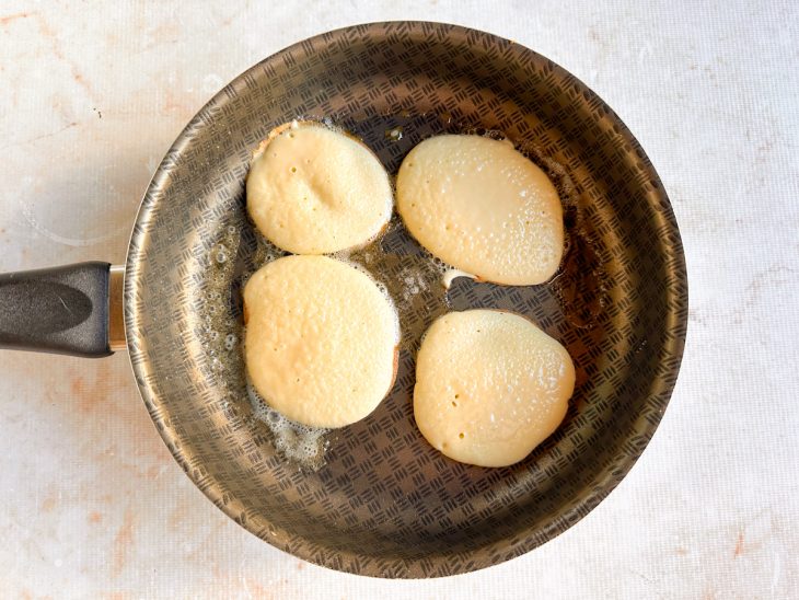 Porções da massa acomodadas na frigideira.