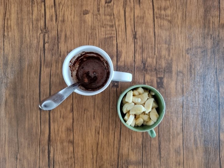 Caneca com ingredientes do bolo e outra com pedaços de banana.