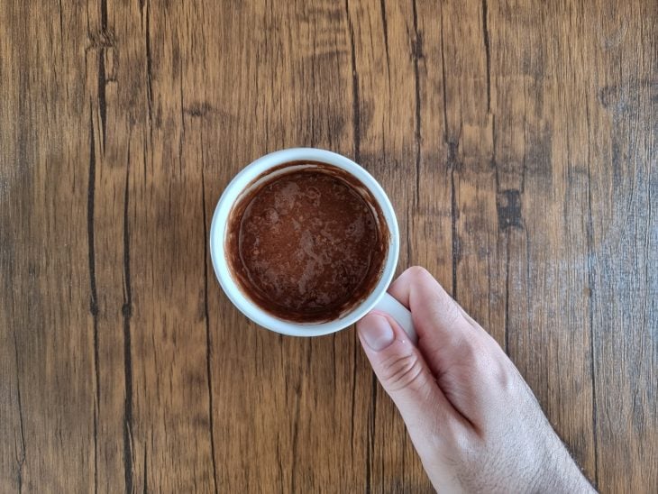 Caneca branca com massa de bolo.