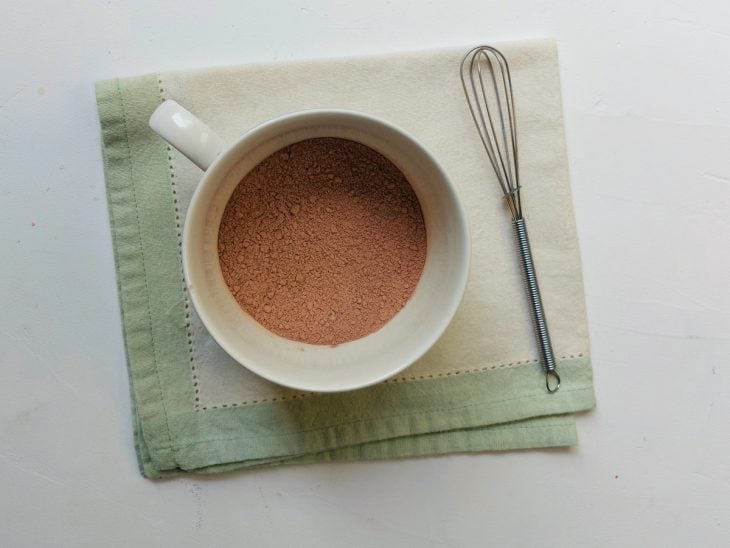 Uma caneca com a mistura de açúcar, cacau e farinha.