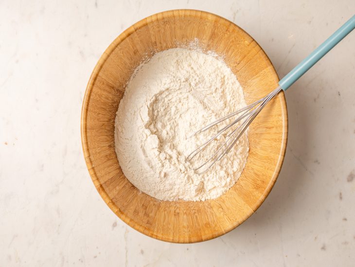Ingredientes secos peneirados e misturados em um recipiente.
