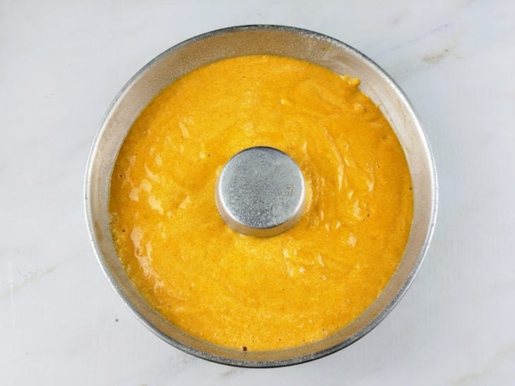 Massa de bolo de cenoura ainda crua em uma forma de alumínio.