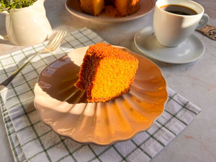 Bolo de cenoura com flocão no liquidificador servido em prato.