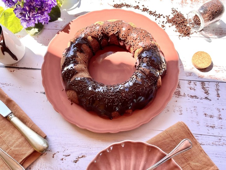 Bolo de cenoura low carb e sem lactose com uma cobertura de chocolate.