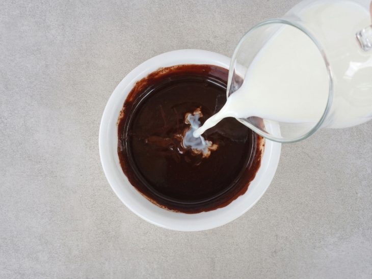 Leite vegetal sendo adicionado ao chocolate derretido.