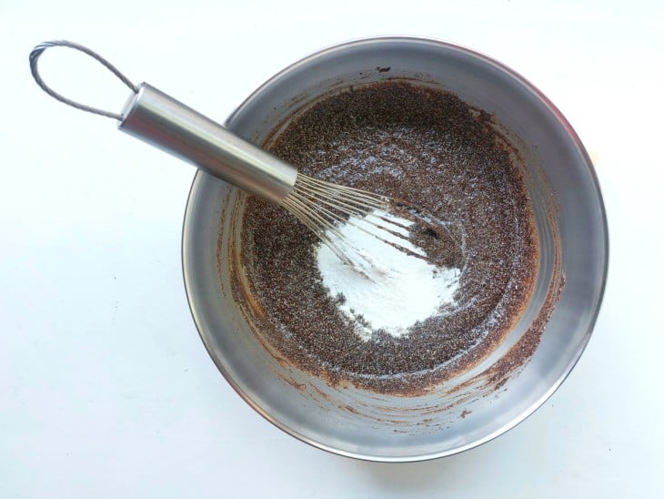 recipiente com a mistura de bolacha e leite com o fermento; Um fouet dentro para mexer.
