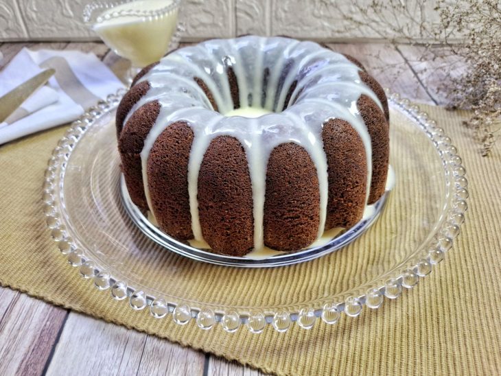 Uma boleira com o bolo de chocolate com cobertura de Ninho.