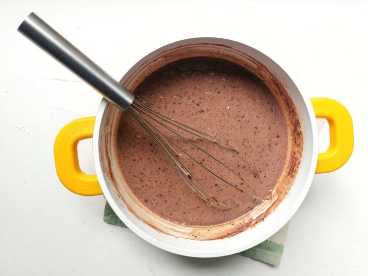 Uma panela com a mistura de leite condensado, creme de leite, chocolate em pó e manteiga.