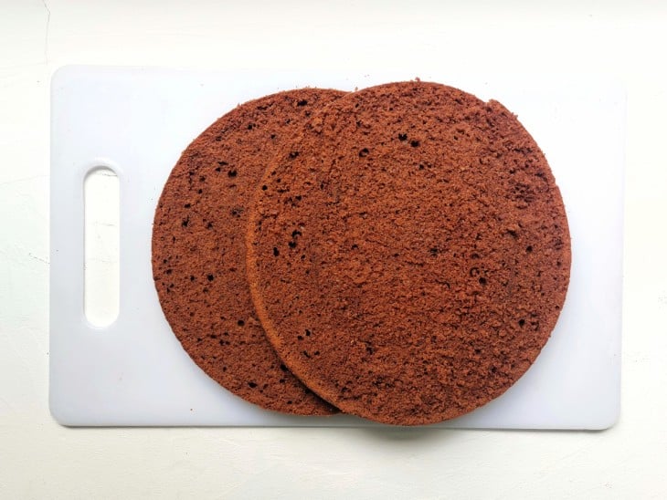 Uma tábua contendo dois discos de massa de bolo de chocolate.