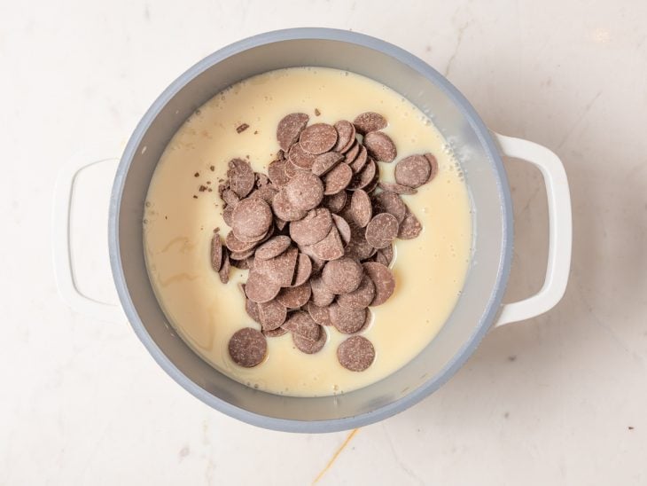 Uma panela com leite condensado e gotas de chocolate.
