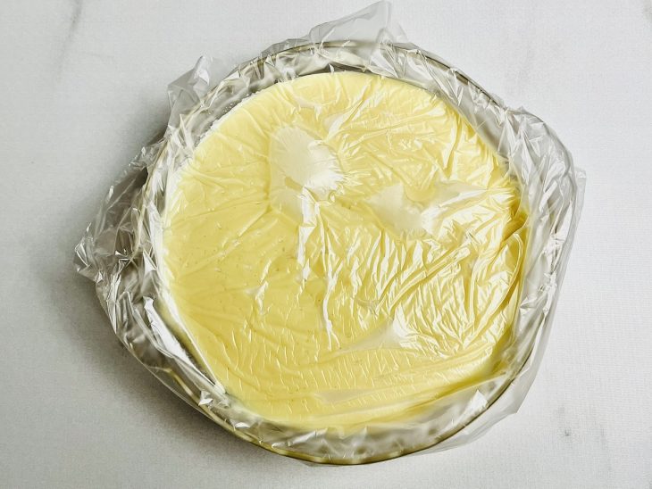 Creme de chocolate branco em um prato coberto com plástico-filme.