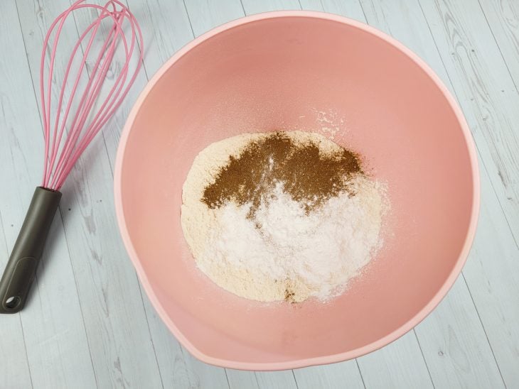 Farinha de trigo, canela e fermento adicionados em uma tigela.